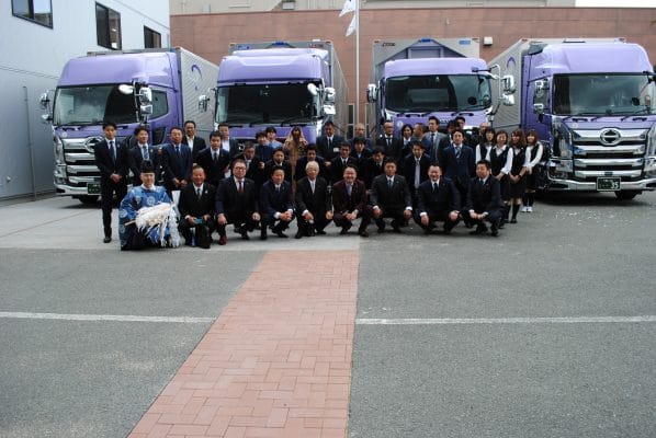 新社屋と35周年トラック前にて集合写真